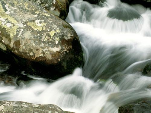 стремительный водопад между круглых камней