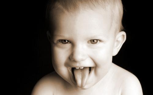 хитрый зубастый малыш показывает язык